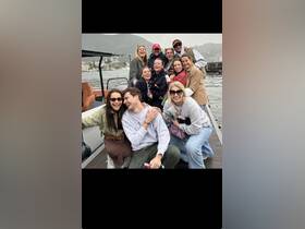 A lively group of friends poses for a fun photo on a boat, capturing the joy of their outing together — perfect for memorable adventures on the water.