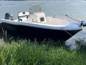 A sleek Robalo boat anchored near the shore, showcasing its elegant design and perfect for fishing or leisure outings on the water.