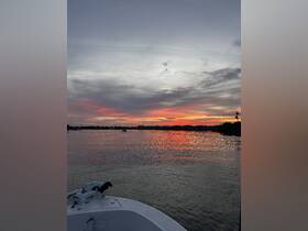 A serene sunset view from the bow of a boat, showcasing vibrant colors reflecting on the water — perfect for peaceful evening cruises.