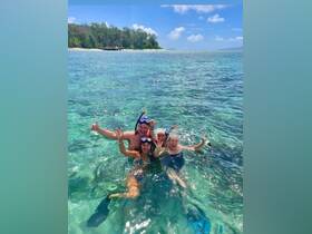 A joyful group of snorkelers celebrates in the crystal-clear waters, showcasing the fun and excitement of underwater adventures.