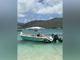 A sleek speedboat named 'Sabali' docked in clear turquoise waters, surrounded by lush hills — perfect for a day of adventure on the water.