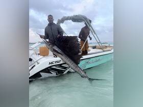 Two fishermen proudly display a sailfish on their boat, showcasing the thrill of deep-sea fishing in crystal-clear waters.