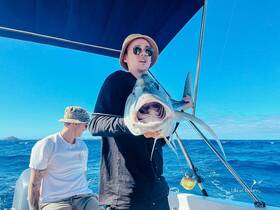 Two anglers celebrate a successful fishing trip on the open ocean, showcasing their impressive catch — a thrilling moment for fishing enthusiasts.