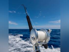 Close-up of a fishing reel against the backdrop of the ocean, showcasing essential fishing gear for an exciting day on the water.