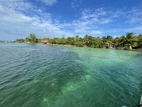 A stunning view of a tropical coastline with lush greenery and clear turquoise waters, perfect for showcasing the beauty of island destinations.