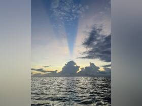 A breathtaking sunset over the ocean, showcasing dramatic clouds and serene waters — a perfect moment for nature lovers and photographers.