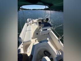 A view of the helm area inside a boat, showcasing the seating and control console, perfect for navigating the waters.