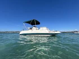 A serene view of a pontoon boat anchored in clear waters, showcasing its sleek design against a vibrant blue sky — perfect for leisurely outings and water adventures.