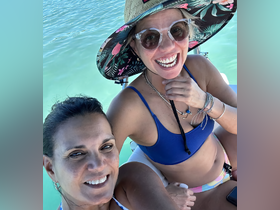 Two friends enjoy a sunny day on the water, capturing a joyful moment aboard a boat — perfect for memorable outings and adventures.