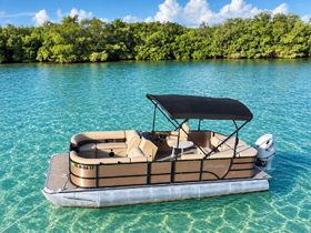 A beautiful pontoon boat anchored in crystal-clear waters, surrounded by lush greenery — perfect for leisurely outings and family fun on the water.