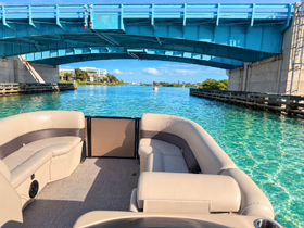 Interior view of a comfortable pontoon boat, showcasing spacious seating and a serene waterway backdrop, perfect for leisurely outings.