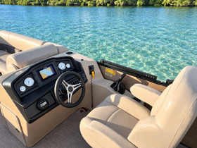 A detailed view of the helm and seating area inside a boat, showcasing the modern controls and comfortable seating, perfect for a day on the water.