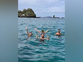 A lively group enjoys snorkeling in crystal-clear waters, showcasing the beauty of the ocean and the excitement of underwater exploration.
