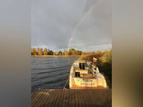 A beautiful Bayliner boat named 'Stella' docked by the water, with a stunning rainbow arching across the sky, creating a picturesque scene perfect for boating enthusiasts.