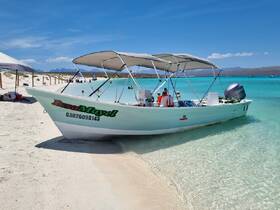A speedboat named 'Issa Mavel' docked on a sandy beach, surrounded by clear turquoise waters — perfect for day trips and water adventures.