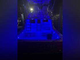 The illuminated interior of a boat showcases its seating and helm area, creating a vibrant atmosphere perfect for nighttime outings.