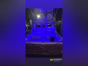 The interior of the 'Reel Time' boat is illuminated with blue lighting, showcasing the seating and helm area, perfect for evening outings and fishing trips.
