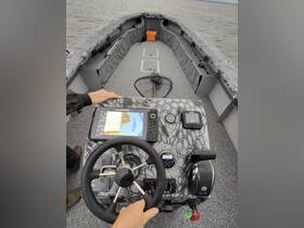 A close-up view of the helm inside a fishing boat, showcasing the steering wheel and electronic controls, perfect for navigating the waters.