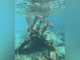 An underwater view of a shipwreck, showcasing the remnants of a vessel resting on the ocean floor, surrounded by marine life — a fascinating site for divers and underwater explorers.