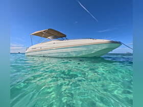 A stunning view of a speedboat anchored in crystal-clear waters, showcasing its sleek design against a vibrant blue sky — perfect for summer adventures on the water.