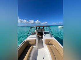 A crew of three enjoys the stunning views from the back of a boat, surrounded by crystal-clear waters — a perfect setting for a day of adventure on the ocean.