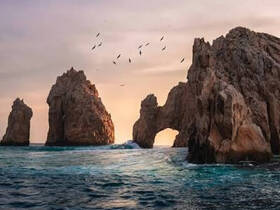 Stunning view of iconic rock formations at sunset, showcasing the natural beauty of the ocean and coastline — a must-see landmark for boat tours.