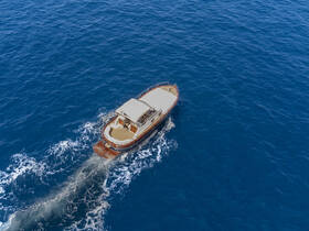 Aerial view of a boat cruising through deep blue waters, showcasing its elegant design and smooth movement.