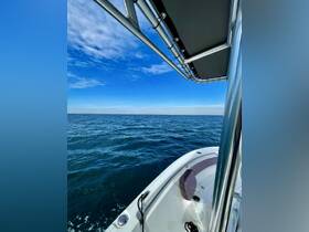 A view from inside a boat showcasing the helm and seating area, with a clear blue sky and calm waters in the background — perfect for a day out on the water.