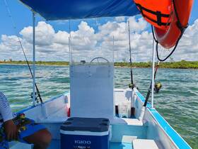 Inside view of a fishing boat featuring the helm and seating area, ideal for a day of fishing adventures on the water.
