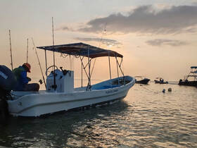 A fisherman prepares his gear on a boat at sunset in Playa del Carmen, capturing the serene beauty of a fishing experience on the water.