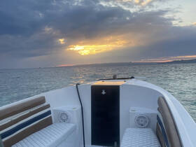 A serene view from the front of a boat at sunset, showcasing the tranquil waters and dramatic sky, perfect for peaceful evening cruises.