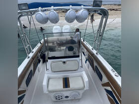 An interior view of a boat's helm and seating area, showcasing a relaxed atmosphere with a guest lounging comfortably.