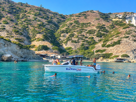 A lively scene with a group enjoying a swim around a boat in crystal-clear waters, perfect for summer adventures and beach outings.