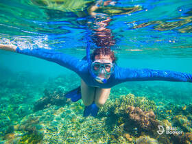 A snorkeler explores vibrant coral reefs underwater, showcasing the beauty of marine life and the thrill of snorkeling adventures.