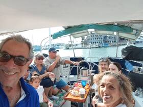 A joyful group enjoys a boat party with food and drinks, capturing a memorable moment together on the water.