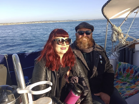 A couple enjoys a sunny day on the water, capturing the essence of a perfect boating experience with the ocean in the background.