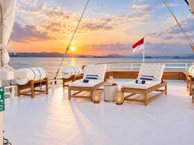 A serene lounge area on a boat, featuring comfortable seating and stunning sunset views over the water — perfect for relaxation and enjoying the scenery.
