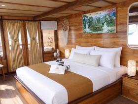 A beautifully designed cabin interior featuring a cozy bed and wooden decor, perfect for relaxing on a boat getaway.