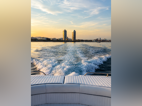 A stunning view from the back of a boat, showcasing the wake and the skyline of a city at sunset — perfect for capturing the essence of a scenic boating experience.