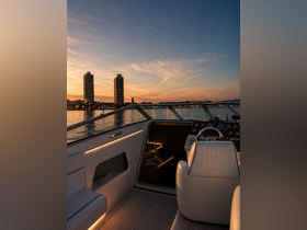 A beautifully lit interior view of a boat's helm and seating area, showcasing a serene sunset over the water — perfect for evening cruises.