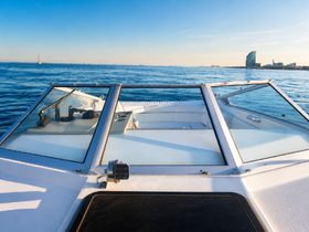 A clear view of the helm and cabin area of a boat, showcasing the sleek design and spacious seating, perfect for a day on the water.
