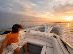 A person enjoys a scenic sunset ride on a boat, capturing the essence of adventure and relaxation on the water.