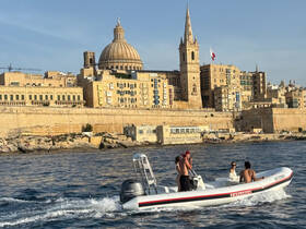A group enjoys a scenic boat ride near the historic architecture of Valletta, Malta, capturing the essence of exploration and adventure on the water.