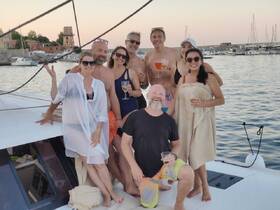 A joyful group of friends celebrates aboard a yacht, enjoying cocktails and the beautiful waterfront scenery — perfect for memorable gatherings and sunset cruises.