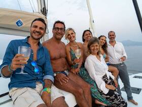A joyful group of friends enjoys cocktails aboard a yacht, capturing the essence of celebration and camaraderie on the water.