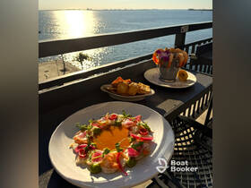 A beautifully presented seafood dish alongside shrimp and snacks, perfect for enjoying a meal with a stunning waterfront view.