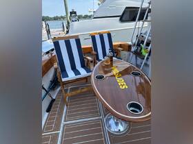 A cozy seating area inside a boat featuring striped chairs and a polished table, perfect for relaxing while enjoying the views on the water.