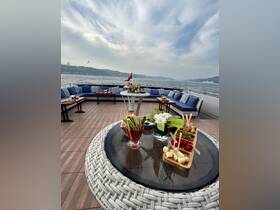 A beautifully arranged dining area on a boat featuring fresh vegetables, cheeses, and cocktails, perfect for enjoying a luxurious day on the water.