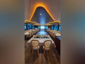 Elegant dining setup inside a boat, featuring beautifully arranged tables and floral decorations, perfect for special events or private dining experiences on the water.