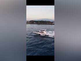 A dynamic aerial view of a speedboat cruising through the water, showcasing its sleek design and performance.